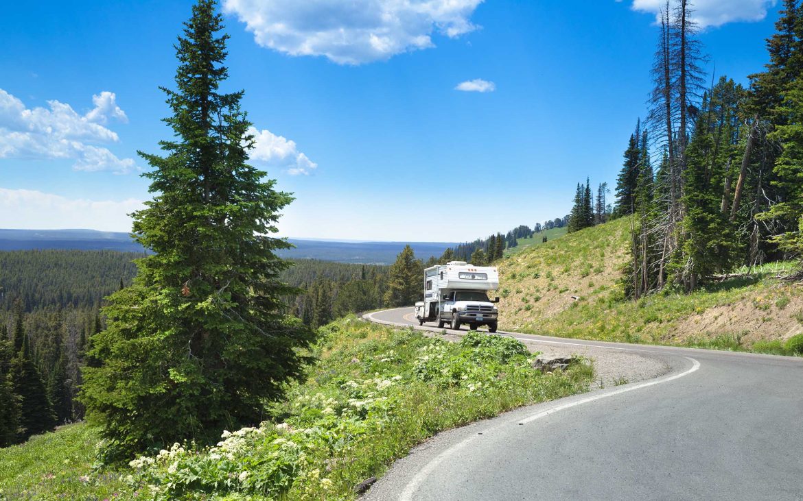 Truck camper navigating the curve of a mountain highway