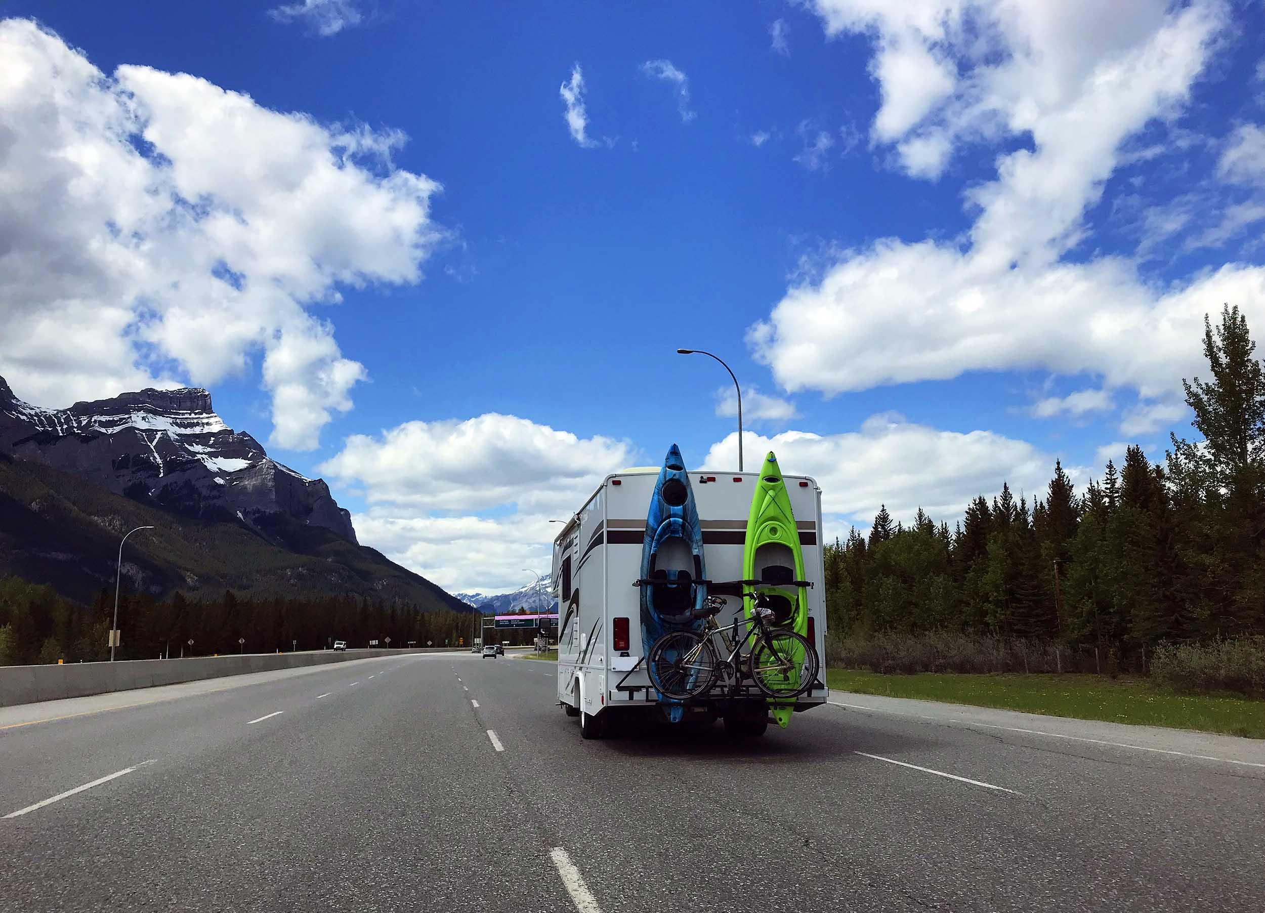 RV with kayaks strapped to it traveling north.