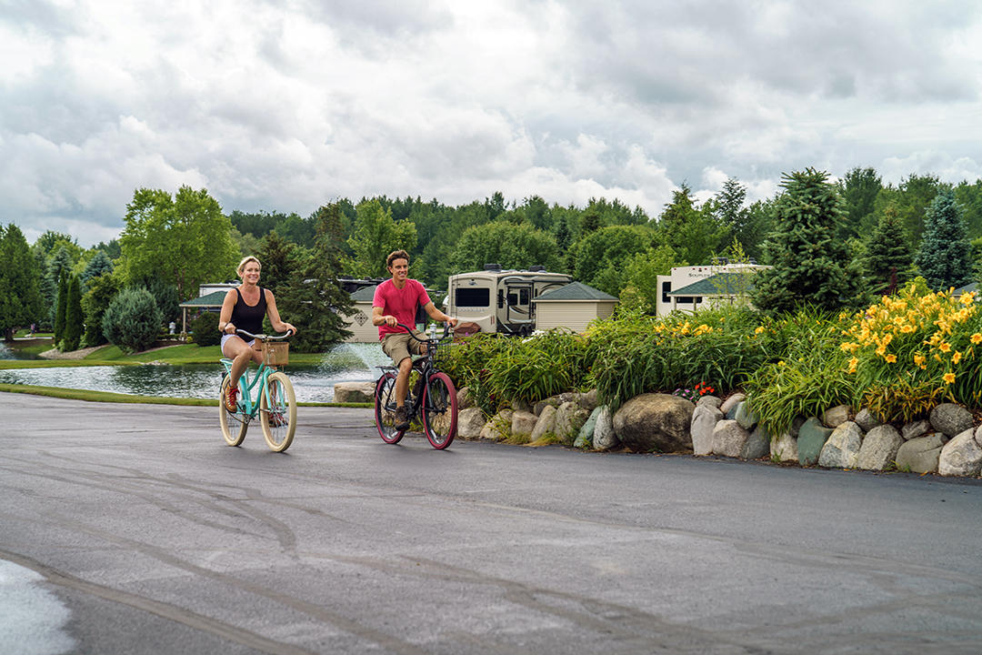 A couple biking on a blacktop path.