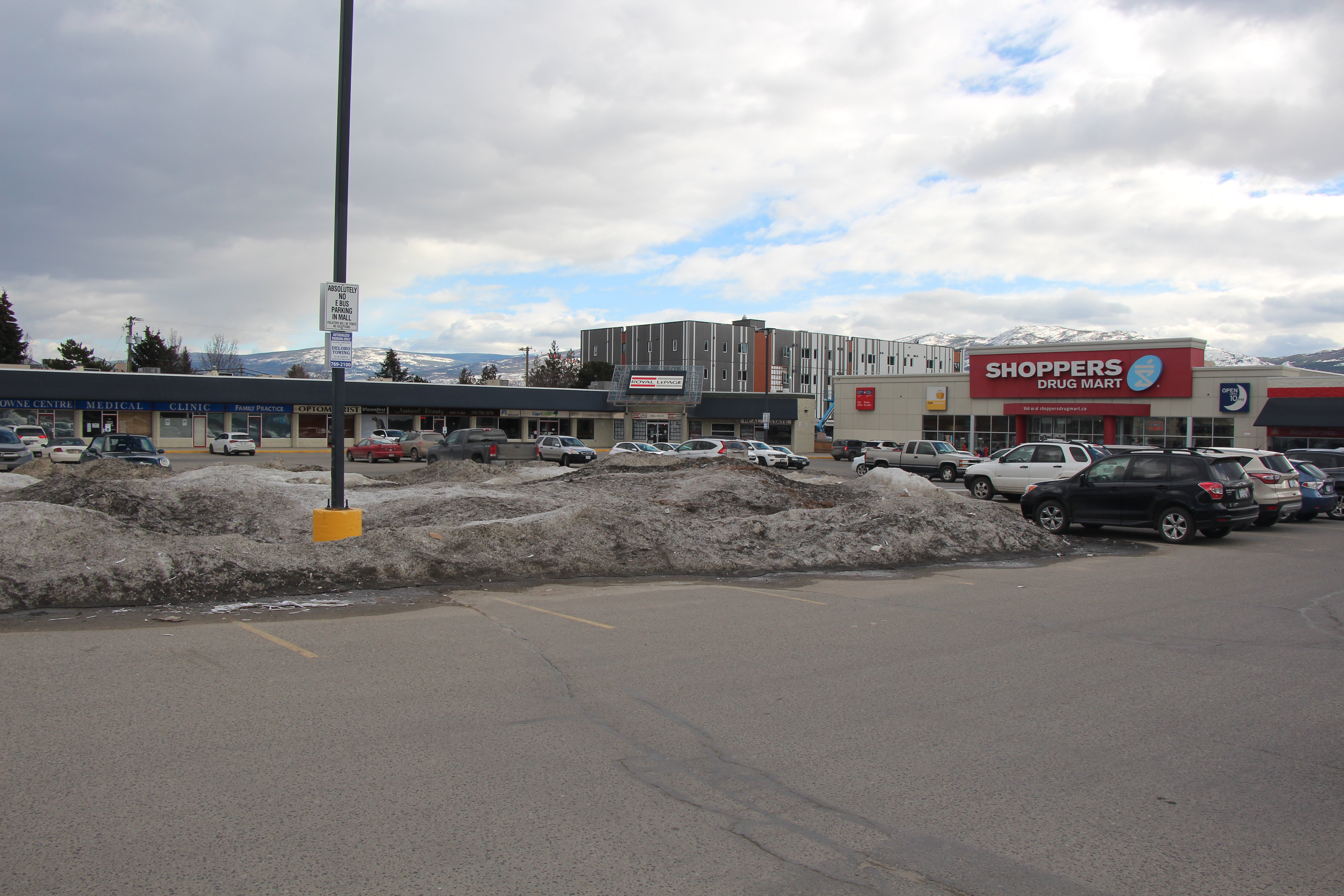 A large snow bank cover a parking lot.