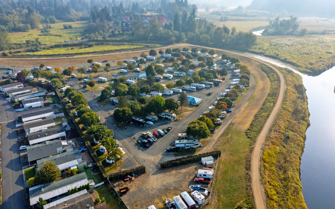 Aerial view of RV park amid lush grass and trees.