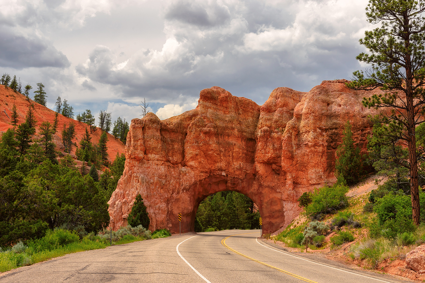 A rock arch over a two-lane highway.