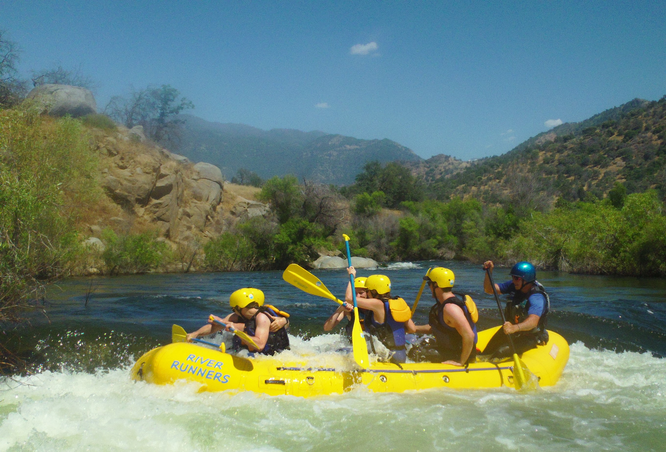 Paddlers in a yellow raft get ready for some whitewater action
