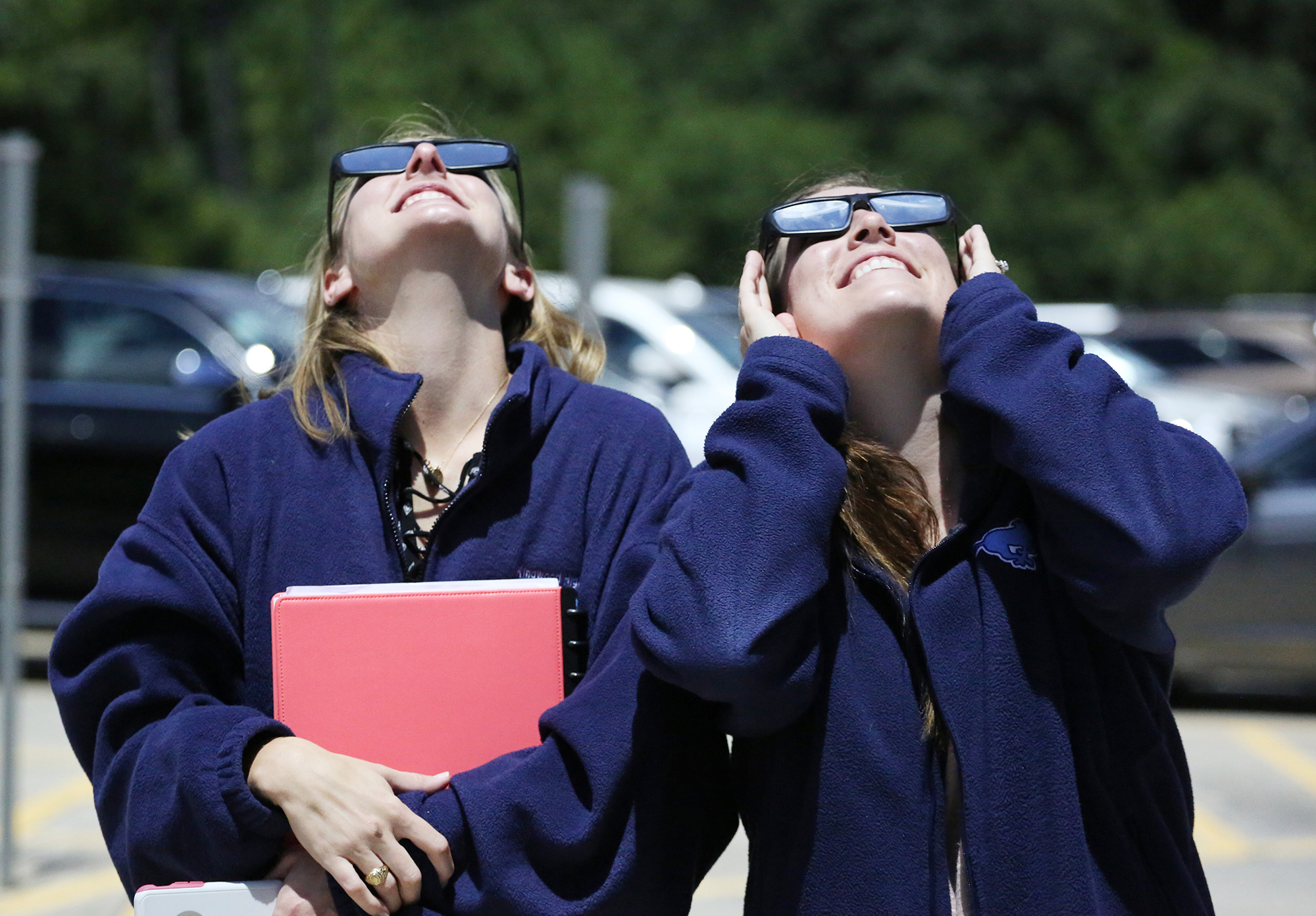 Two woman stare up at the sky during an eclipse.