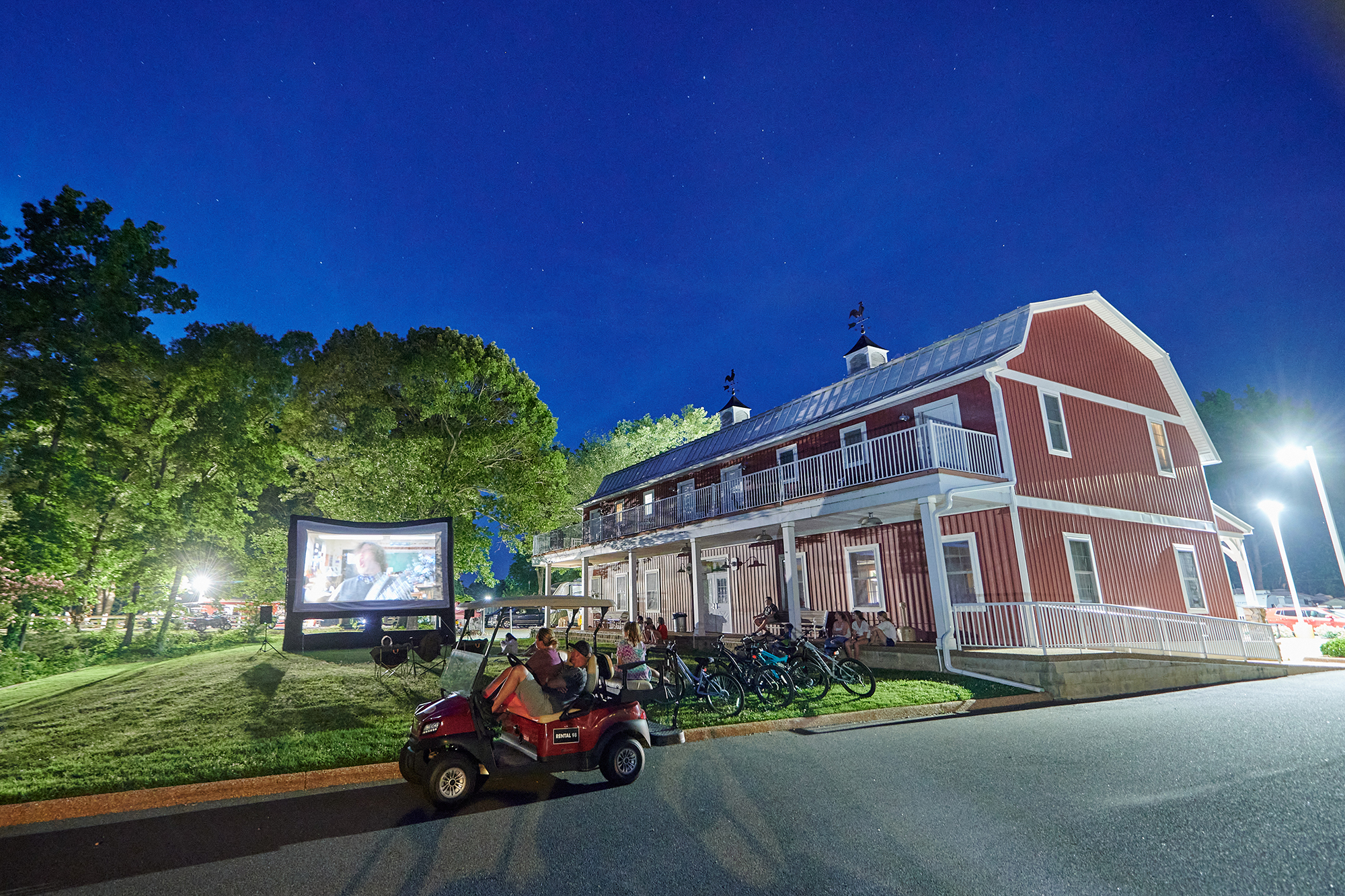 Campers watch an outdoor movie with Jack Black.