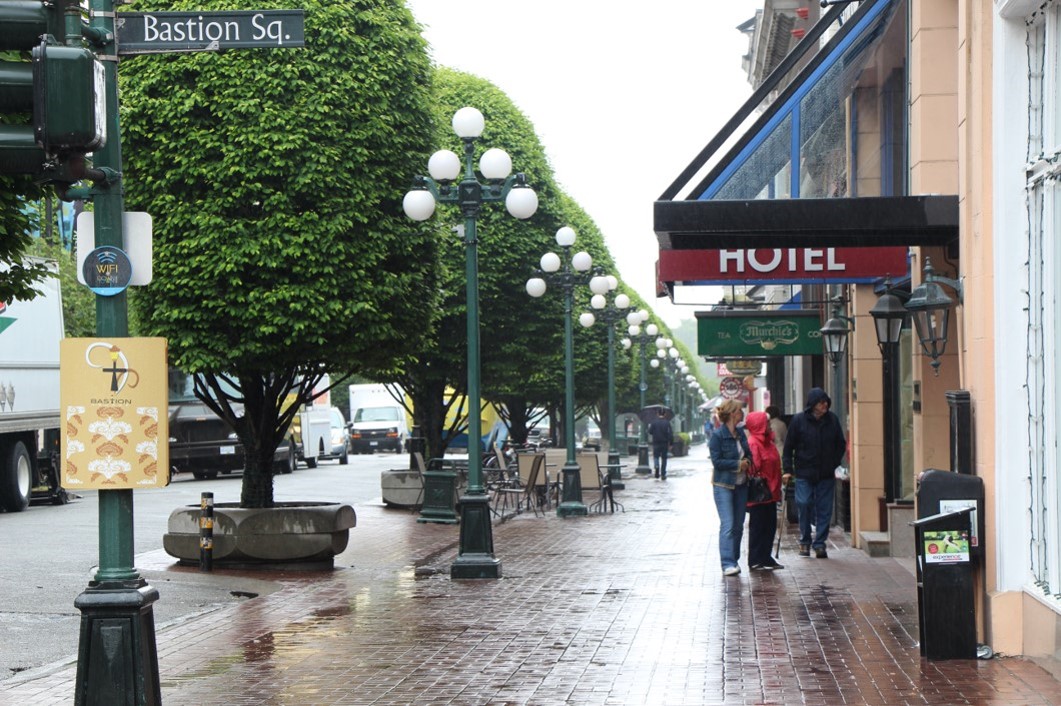 shoppers stroll on a rainy sidewalk