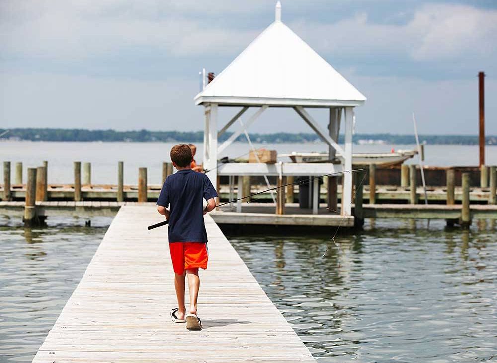 Kid walks toward fishing dock.