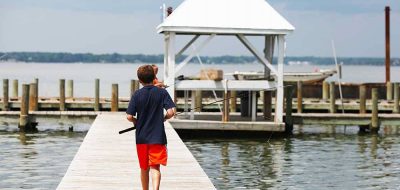 Kid walks toward fishing dock.