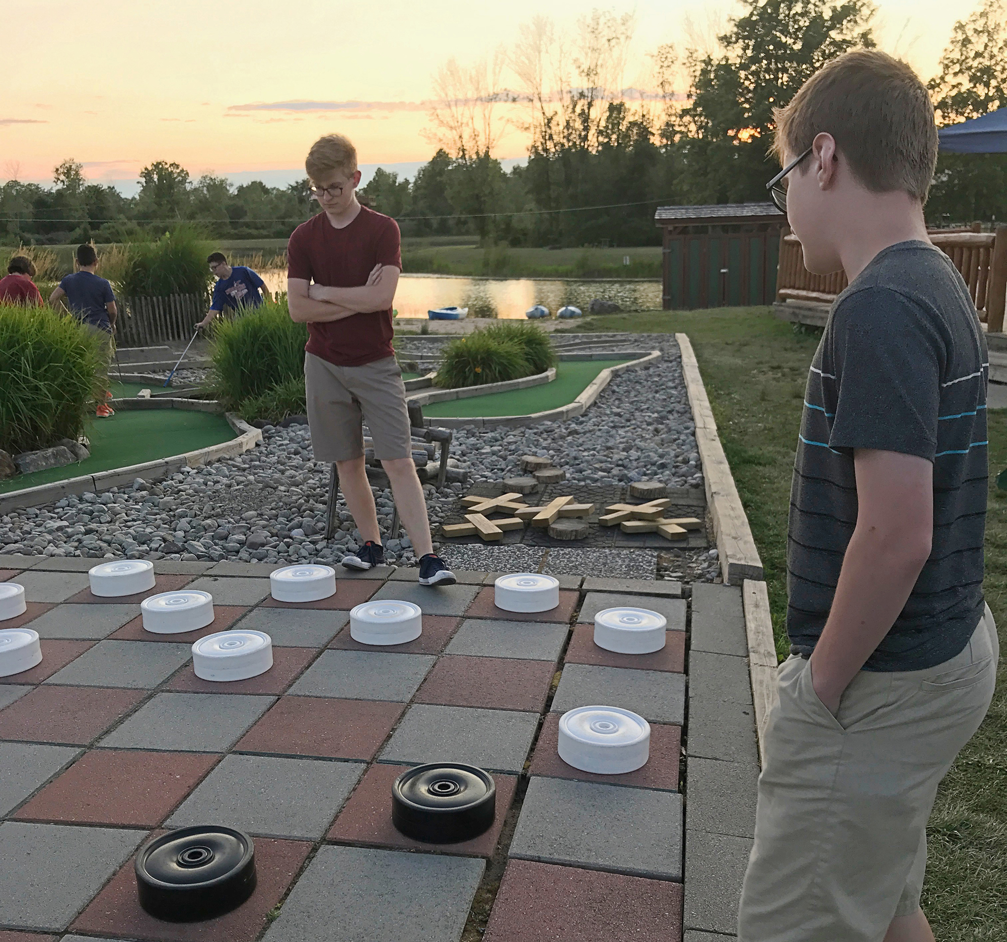 Two boys playing a large game of checkers.
