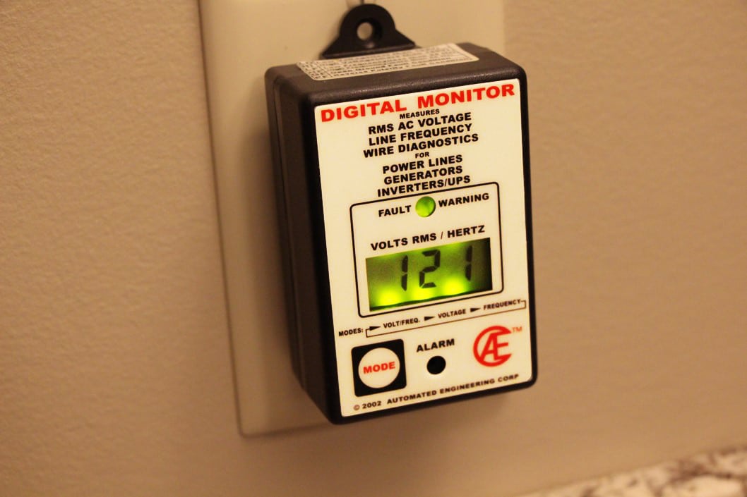 digital voltage monitor plugged into a wall.