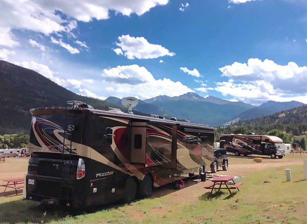 RV in campground backed by mountain range.