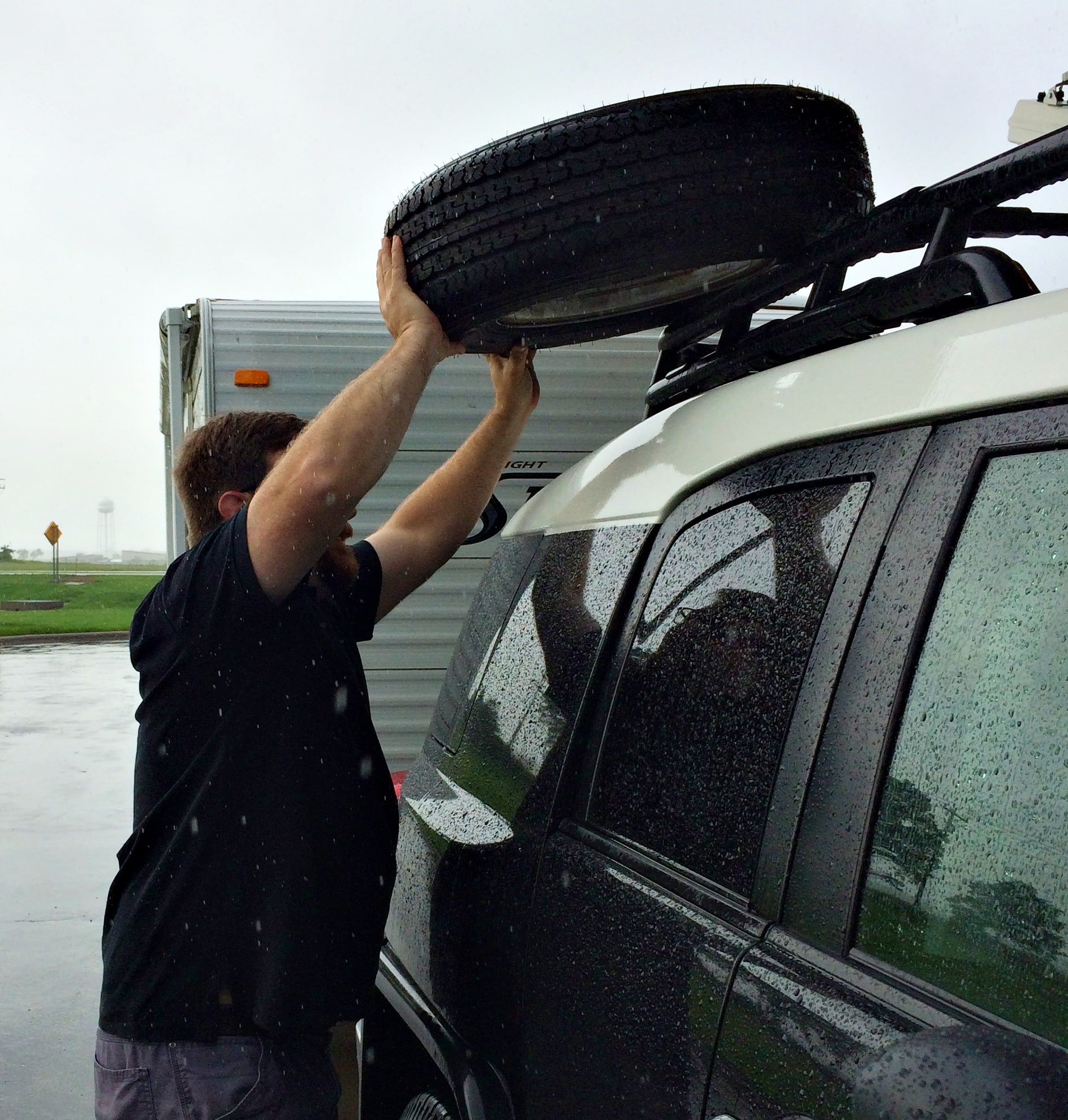 Man dealing with tire blowout in the rain.