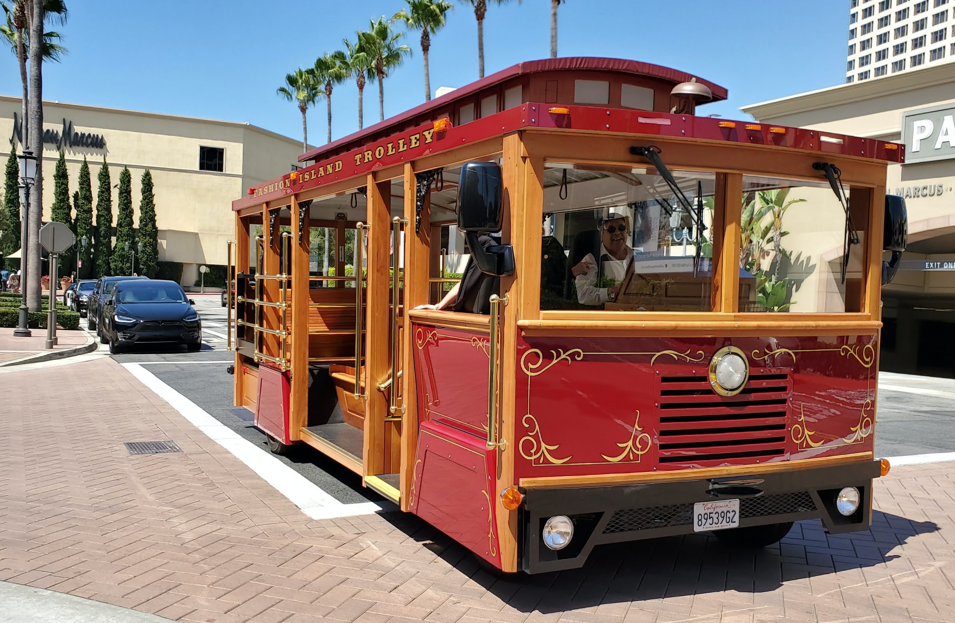 Colorful red trolley near a Neiman Marcus store.