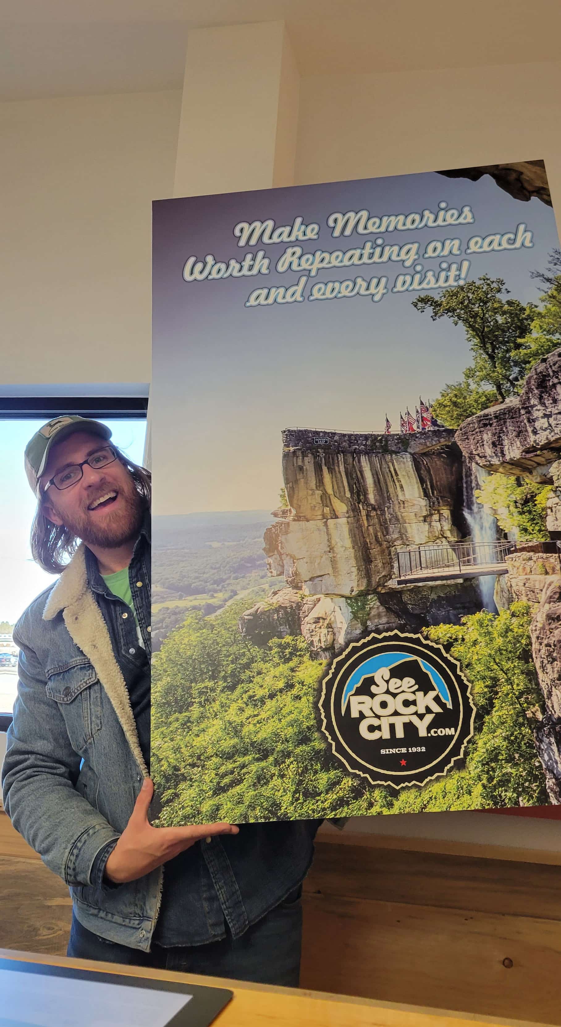 Man holding a sign promoting Rock City.