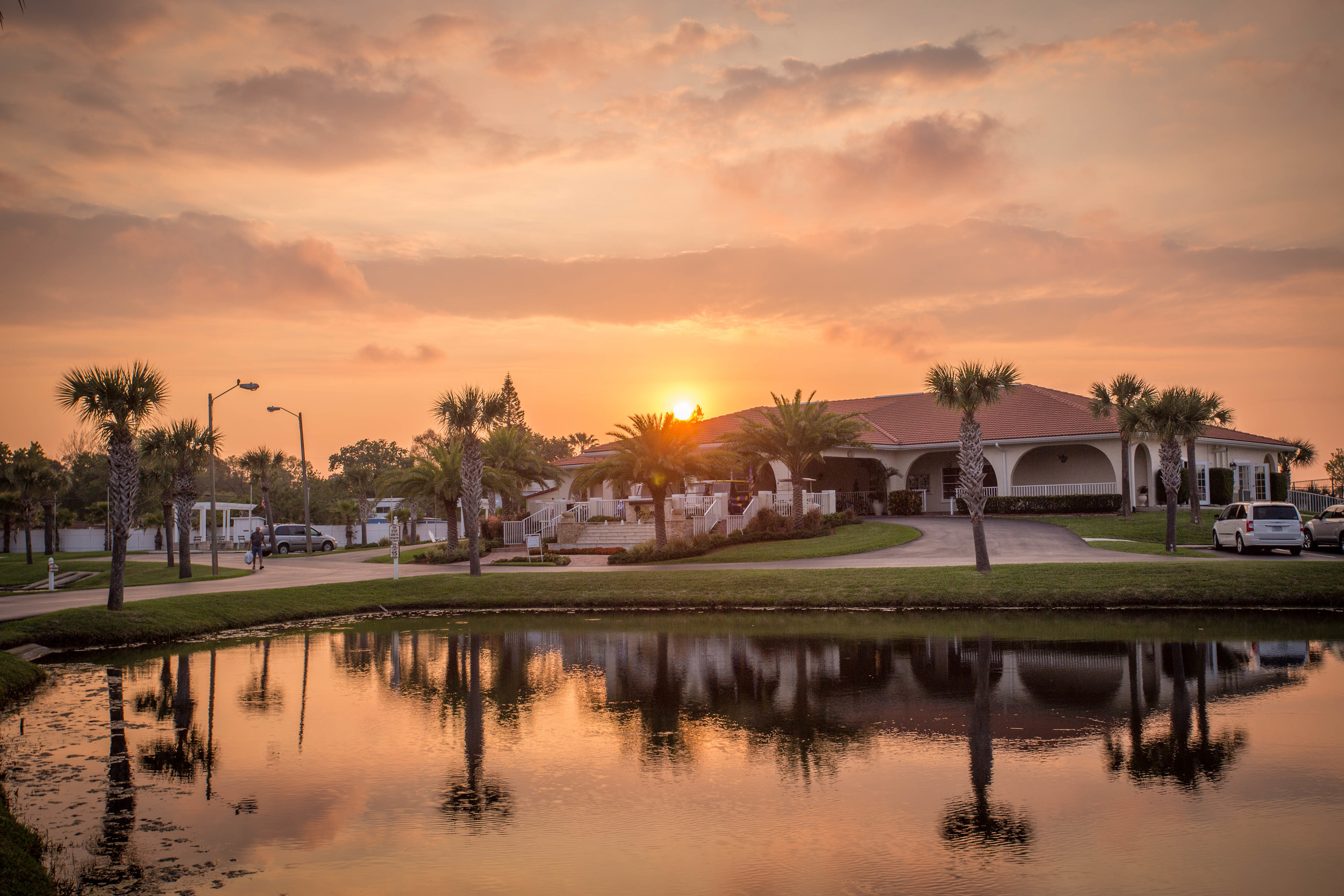 Sun setting over a resort building.