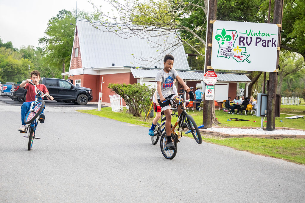 Two kids doing wheelies at RV park.