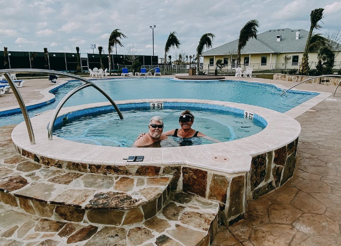 A couple in a hot tub with flagstone covering.