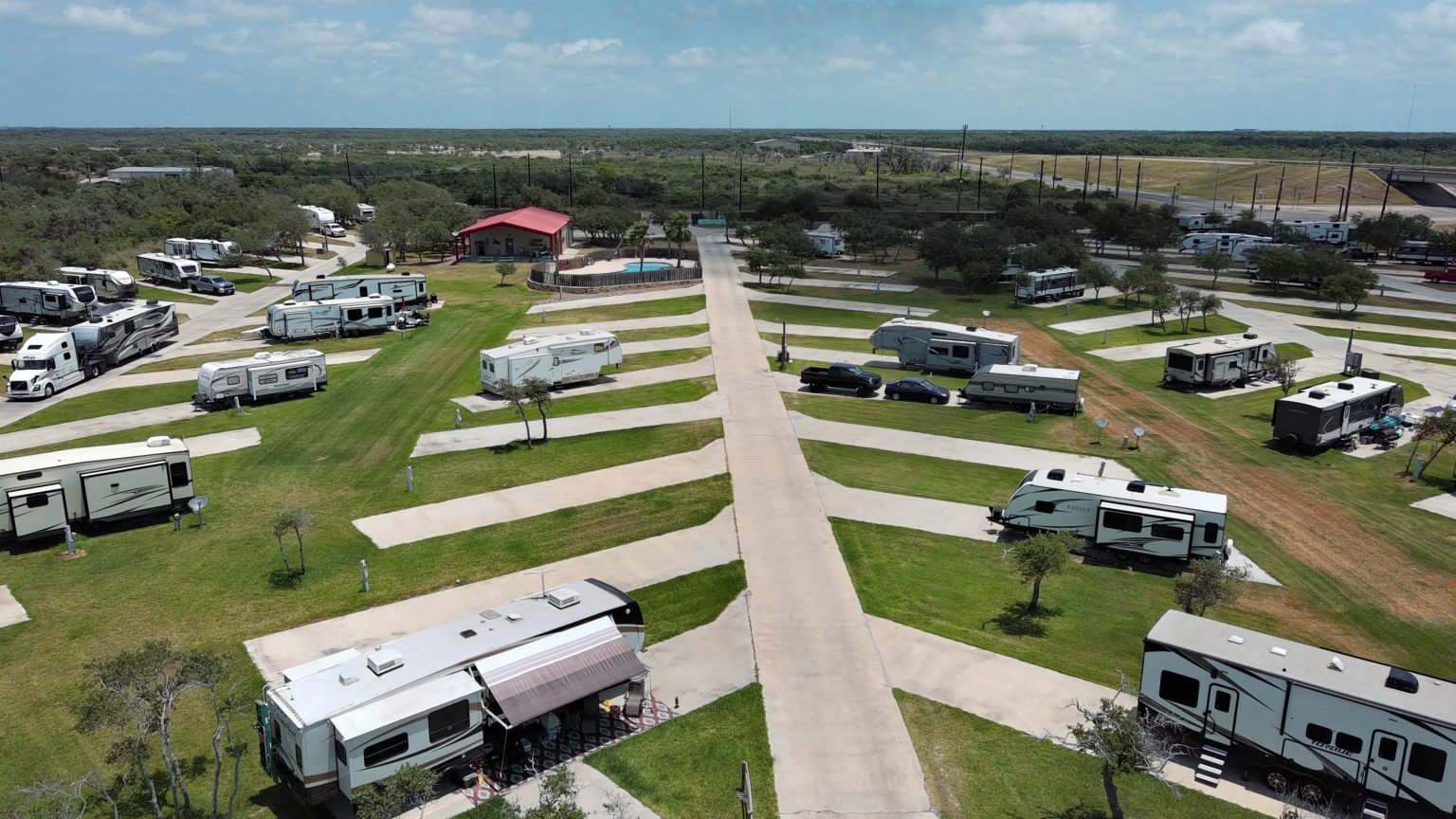RVs in concrete spots with ocean horizon in background.