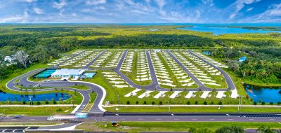 Exciting Encore Resorts — Aerial view of RV park in lush setting.