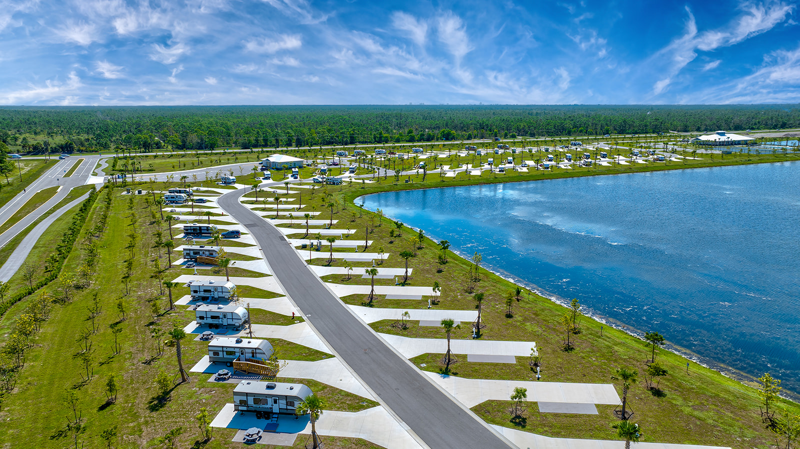 RVs in sites along a lakeshore.