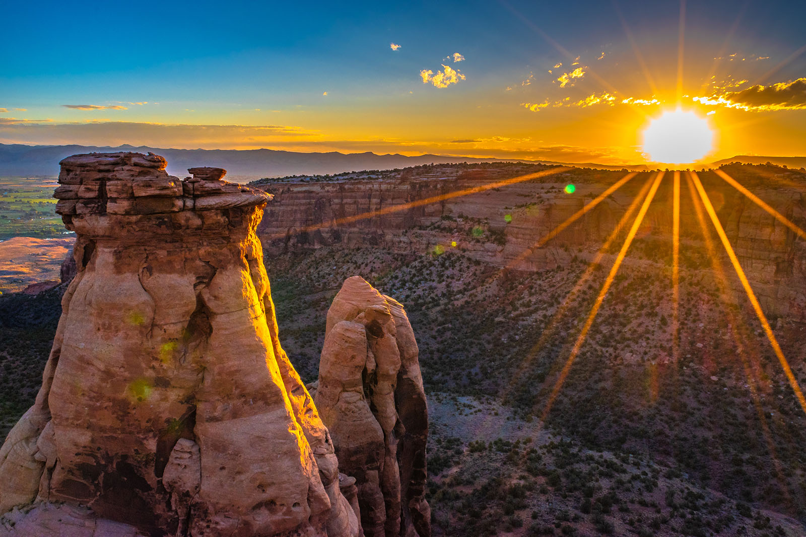 Sun dips over rocky desert landscape.