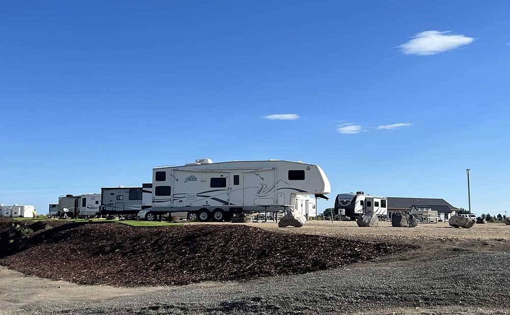 Fifth-wheel on a site against a blue sky.
