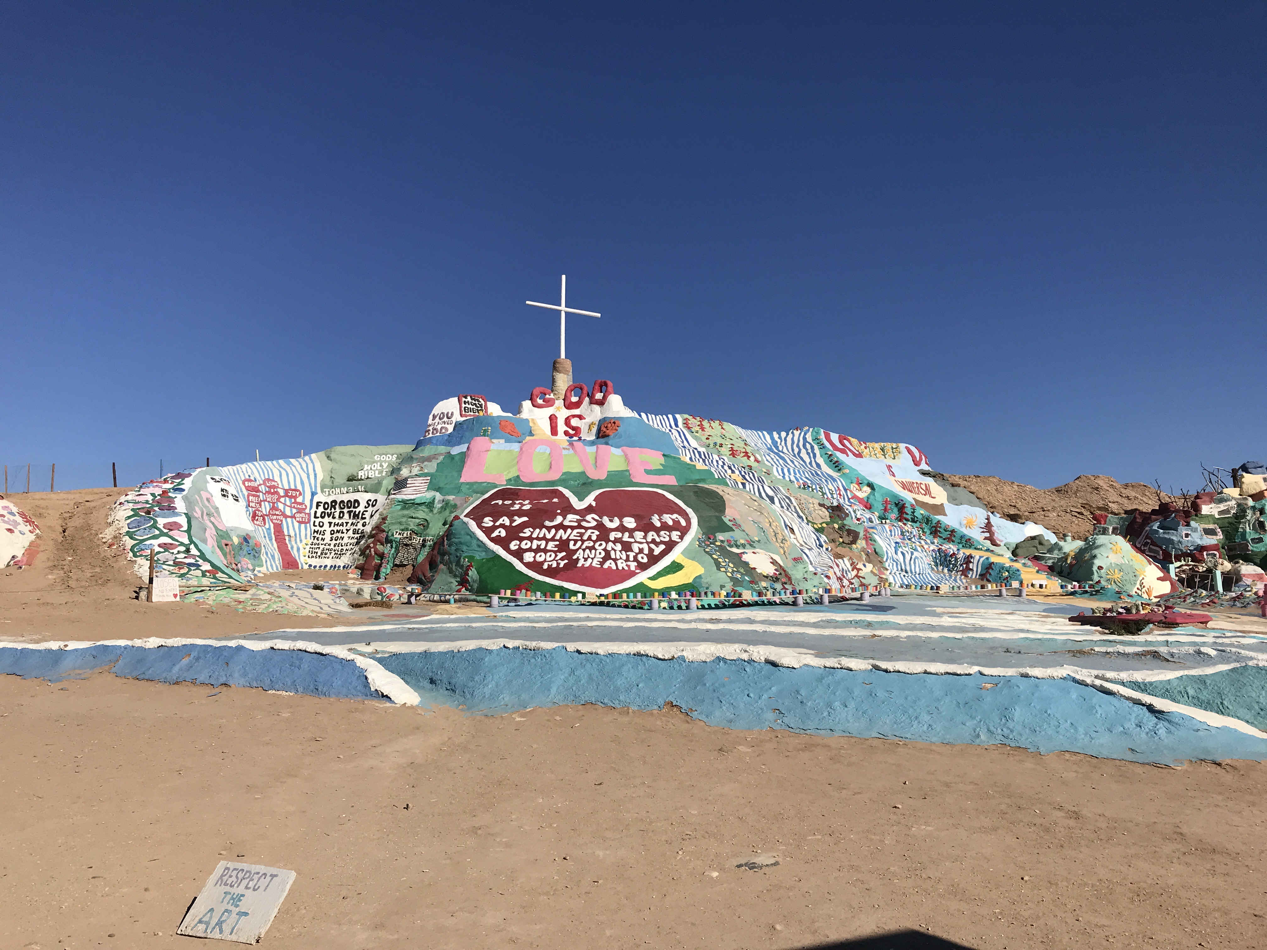 Mound covered in religious-themed graffiti and artwork.