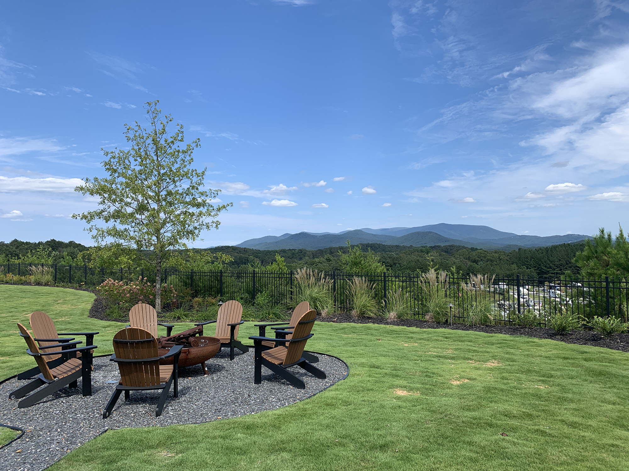 Adirondack chairs arrayed around a table with sweeping view in background.